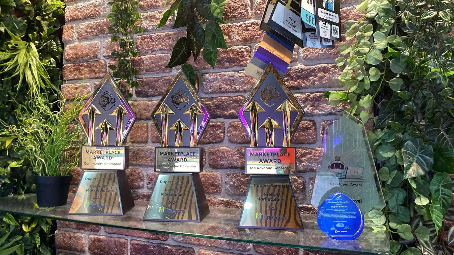 Our HighLevel awards on a shelf: Marketplace Awards for Community Champion (2025) and Top Revenue Generator (2024 and 2025), a Developer Award and a Grateful Recognition plaque